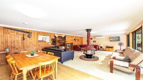 a living room with a table and a fireplace at Barkeldine Farm Country Retreat in Bucca-Wauka