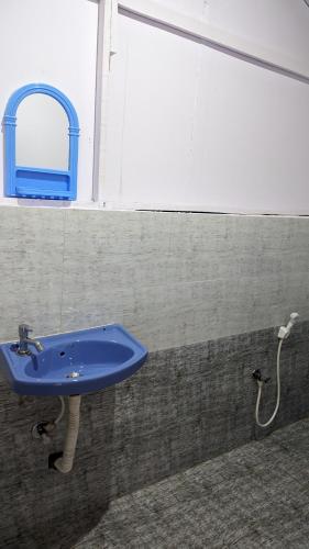 a blue sink in a bathroom with a window at Shree Sai Beach Stay in Arambol