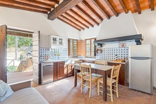 a kitchen with a table and a refrigerator at Rustico immerso nella natura a due passi dal mare in Strettoia