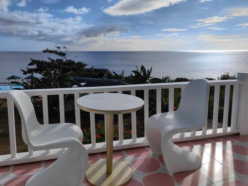 a balcony with a table and chairs and the ocean at Eastern Garan Hen Yuan Resort in Siquijor