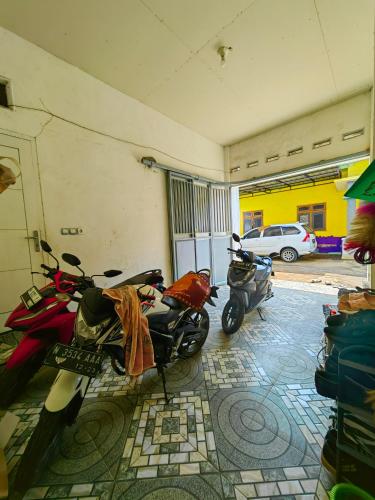two motorcycles parked in a building with a garage at Nina Guest House UIN Malang in Ngadipuro