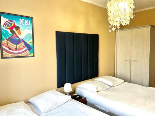 a bedroom with two beds and a chandelier at The Chateau 45Pers, 30min from Sea in Amayé-sur-Orne