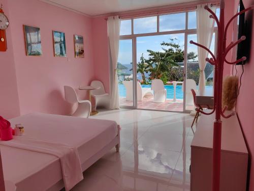 a bedroom with a bed and a view of a pool at Eastern Garan Hen Yuan Resort in Siquijor