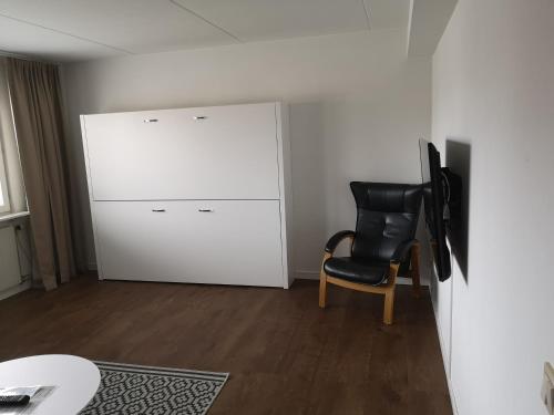 a room with a white cabinet and a black chair at Simloc Hotel Drottninggatan in Arjeplog
