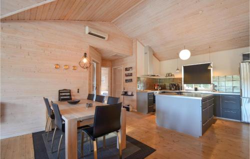 a kitchen and dining room with a table and chairs at Holiday Home Kærsangervej Ebeltoft in Øksenmølle