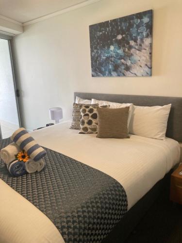 a bedroom with a large bed with pillows at Waves Maroochy River in Maroochydore