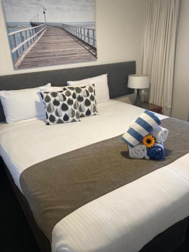 a hotel room with a bed with a stuffed animal on it at Waves Maroochy River in Maroochydore