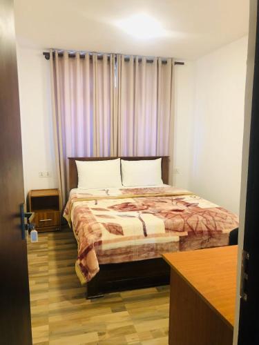 a bedroom with a large bed with a purple curtain at R21 Nuwara Eliya in Nuwara Eliya