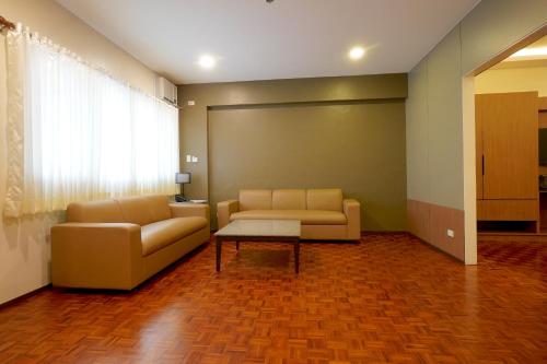 a living room with two couches and a table at Tropicana Suites in Manila