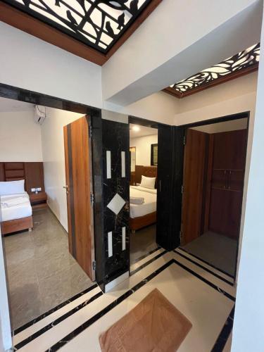a view of a room with two beds and a mirror at Khushi Riverside Resort & Spa in Mahabaleshwar