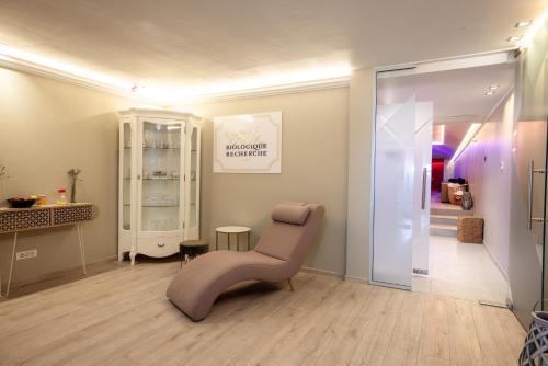 a living room with a pink chair in a room at Tresor Le Palais Timisoara, Curio Collection by Hilton in Timişoara