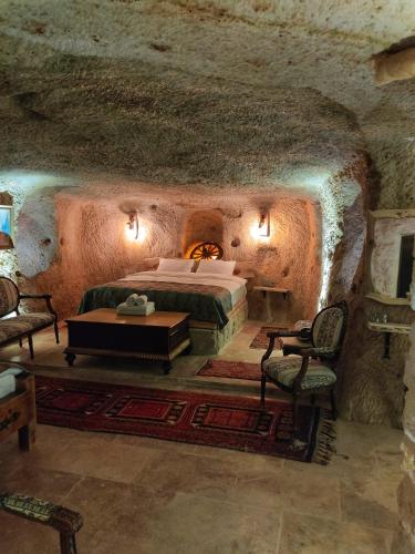 a bedroom with a bed in a stone cave at Lubberona Cave Cappadocia in Nar
