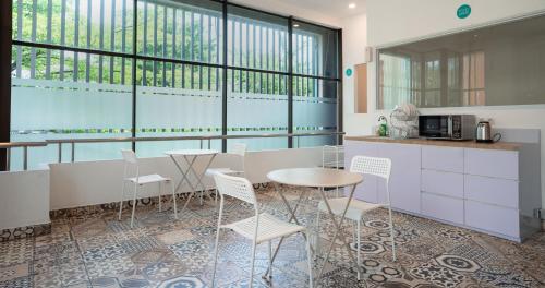 a kitchen with a table and chairs and windows at Bobopod Slamet Riyadi, Solo in Solo