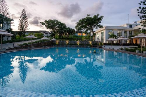 a swimming pool with blue water in front of a building at Edensee Kega Beach Resort in Ke Ga