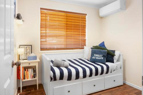 a small bedroom with a bed with a window at Bellevue Lodge Guest Favourite, Hot Spa, Walk to Town in Rainbow Beach