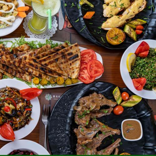 a wooden table with plates of food on it at فندق بغداد Baghdad International Hotel in Baghdad