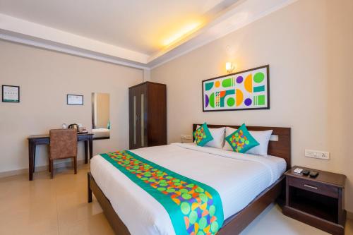 a bedroom with a large bed and a desk at Treebo Ivory White Inn in Bengaluru