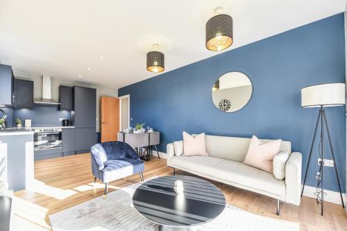 a living room with a couch and a blue wall at Luxury Prime Location Manchester Flat in Manchester