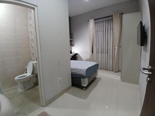 a bathroom with a bed and a toilet in a room at Oren Stayz ICE BSD in Pagedangan