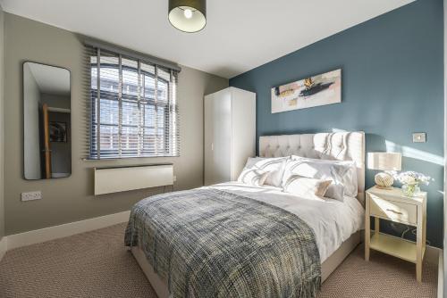 a bedroom with blue walls and a bed with a mirror at Luxury Prime Location Manchester Flat in Manchester