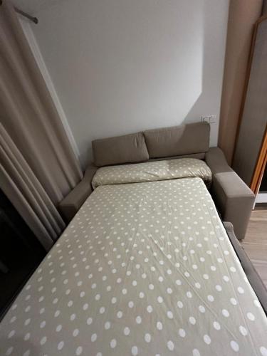 a bed with polka dot sheets in a small room at Brand new studio apartment in Ardales