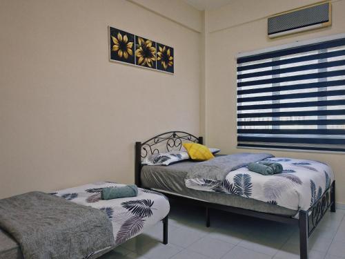 een slaapkamer met twee bedden en een raam bij Casuarina Lot-1103 Malacca in Melaka