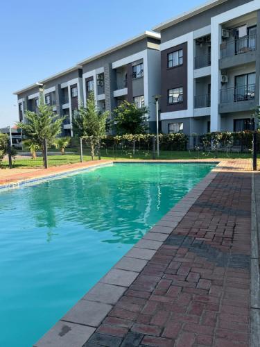 an empty swimming pool in front of a building at Cozy-corner in Gaborone
