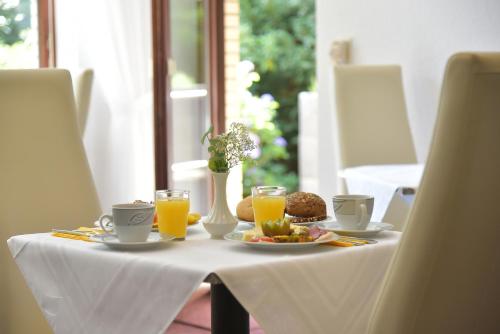 a table with a plate of food and orange juice at Pension Haus Bambi in Mölln