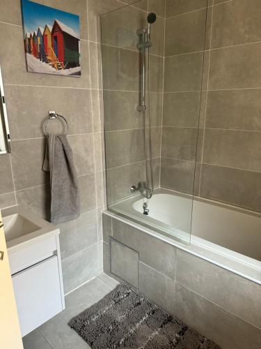 a bathroom with a shower with a tub and a sink at Cozy-corner in Gaborone