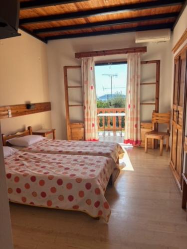 a bedroom with a bed and a large window at Villa Makis Studios in Skiathos Town