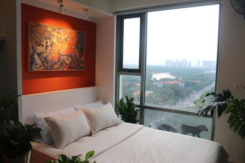 a bedroom with a white bed and a large window at Work & Rest Suite SECC in Ho Chi Minh City