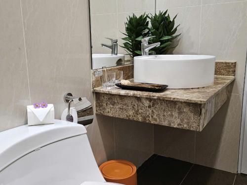 a bathroom with a white sink and a toilet at Work & Rest Suite SECC in Ho Chi Minh City