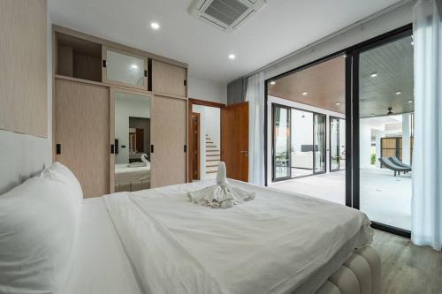 a bedroom with a large white bed and a large window at Peaceful Paradise in Saiyuan Villa V147 in Ban Saiyuan (1)