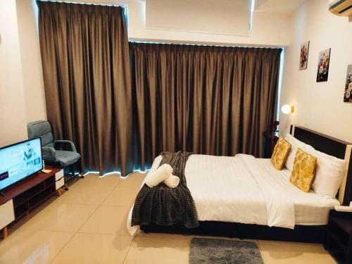a bedroom with a bed and a flat screen tv at Cozy Haven Perfect Studio Getaway in Petaling Jaya