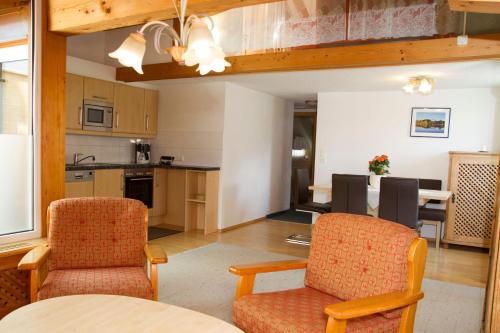 a kitchen and living room with two chairs and a table at Apartmenthaus Brixen & Haus Central in Brixen im Thale