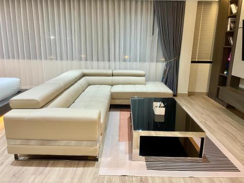 a living room with a white couch and a glass table at indigo Hotel Hatyai in Ban Kohong
