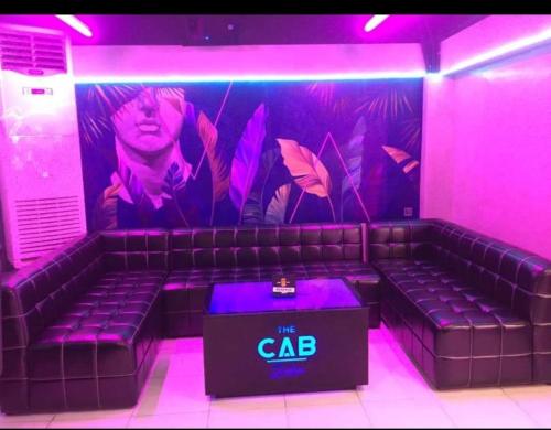a purple room with a couch with a cda sign on it at DG Budget Hotel Salem in Manila