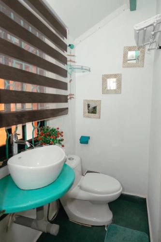 a bathroom with a white sink and a toilet at Cozy Dream Apartment in Anjuna