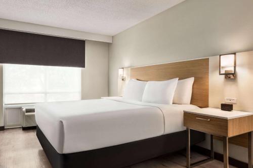 a large white bed in a room with a window at Wyndham Garden Duluth in Duluth