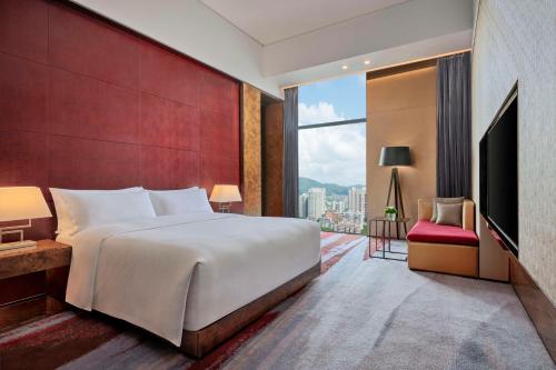 a bedroom with a large bed and a large window at Hilton Guangzhou Tianhe - Free Shuttle Bus and Registration Counter Available during Canton Fair Period in Guangzhou
