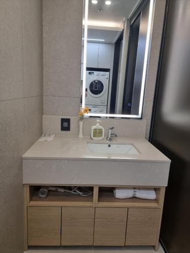 a bathroom with a sink and a mirror at 부산 서면 레지던스 신축 힐링 하우스 in Busan