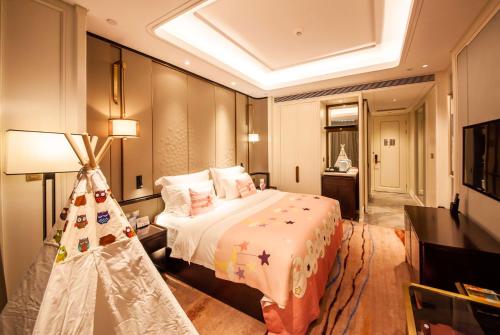 a bedroom with a large bed in a room at Wyndham Qingdao l Free Fixed-Time Shuttle Service Between Hotel and Airport & North Railway Station l Outdoor Children's Amusement Park l 1-Hour Play Snooker or Table Tennis in Qingdao