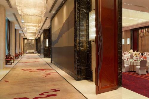 a hallway of a restaurant with tables and chairs at Wyndham Qingdao l Free Fixed-Time Shuttle Service Between Hotel and Airport & North Railway Station l Outdoor Children's Amusement Park l 1-Hour Play Snooker or Table Tennis in Qingdao