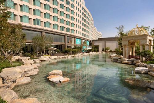 a pool of water in front of a building at Wyndham Qingdao l Free Fixed-Time Shuttle Service Between Hotel and Airport & North Railway Station l Outdoor Children's Amusement Park l 1-Hour Play Snooker or Table Tennis in Qingdao