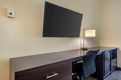 a desk with a chair and a television on a wall at Sleep Inn & Suites Port Charlotte-Punta Gorda in Port Charlotte