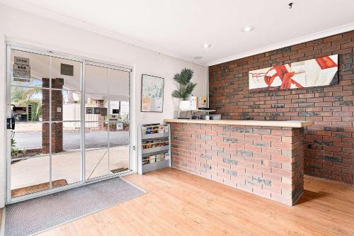 una cocina con una pared de ladrillo y una encimera en Econo Lodge Border Gateway Wodonga, en Wodonga