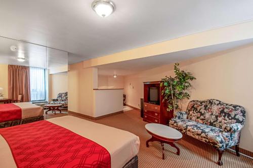 a hotel room with two beds and a chair at Econo Lodge Metro in Arlington