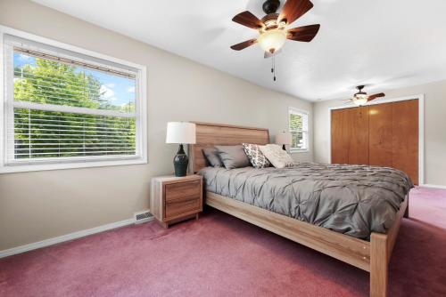 a bedroom with a bed and a ceiling fan at TRAVERSE CITY RETREAT with Hot tub Games Pets in Traverse City