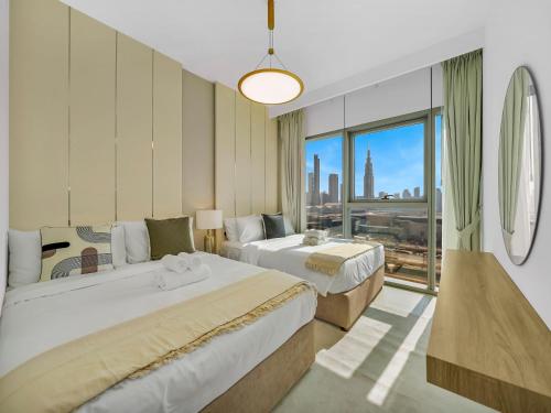 a hotel room with two beds and a large window at Premium Two-Bedroom Apartment with Private Balcony & Full Burj Khalifa Views by Al Fannan Holiday Homes in Dubai