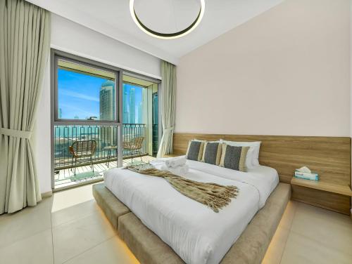 a bedroom with a large bed and a large window at Premium Two-Bedroom Apartment with Private Balcony & Full Burj Khalifa Views by Al Fannan Holiday Homes in Dubai